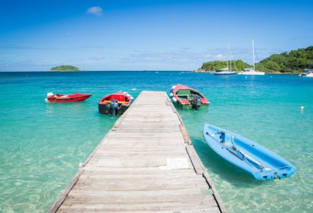 Caribbean Island - three boats are docked at the end of a pier