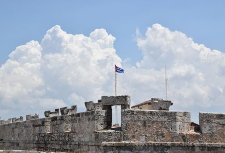 Cuban Flag - a flag flying on top of a stone wall