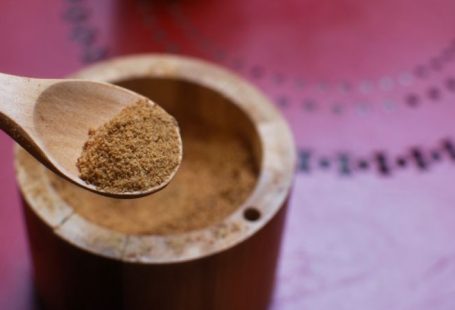 Coconut Sugar - brown wooden round container on pink textile