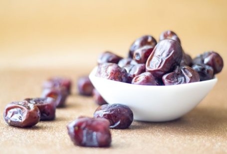 Dates - brown round fruit on white ceramic bowl