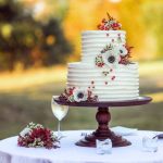 Wedding Cake - white and red floral cake on brown wooden stand