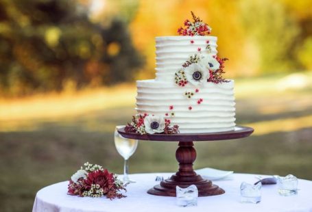 Wedding Cake - white and red floral cake on brown wooden stand