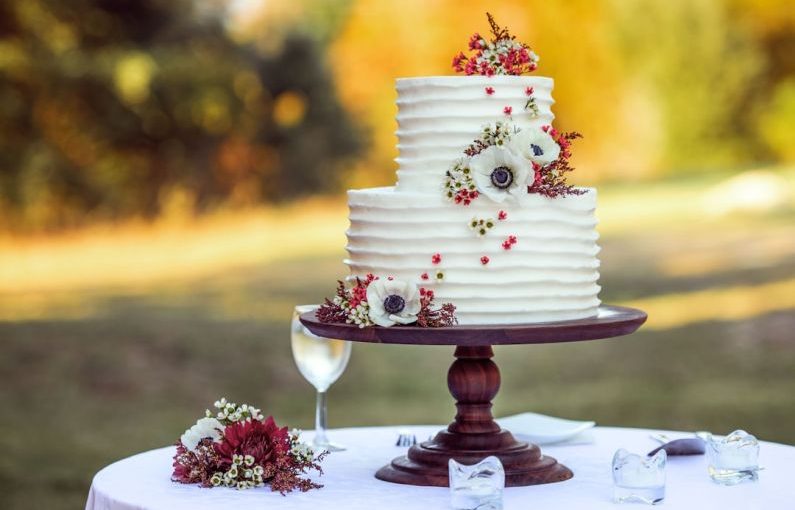 Wedding Cake - white and red floral cake on brown wooden stand