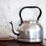 Tea Pot - stainless steel kettle on brown wooden table