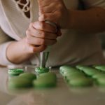 Pastry Chef - selective focus photography of woman putting icing on cupcakes