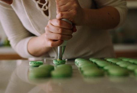 Pastry Chef - selective focus photography of woman putting icing on cupcakes