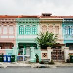 Colonial Map - a row of multicolored buildings with a tree in front of them