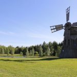 Traditional Mill - black windmill on green grass field during daytime