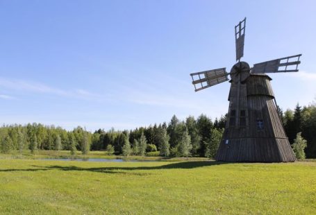 Traditional Mill - black windmill on green grass field during daytime