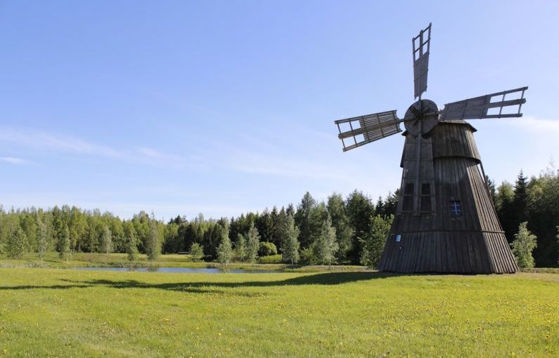 Traditional Mill - black windmill on green grass field during daytime