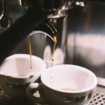 Extraction Machine - two white ceramic mugs on coffeemaker