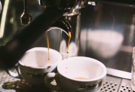 Extraction Machine - two white ceramic mugs on coffeemaker