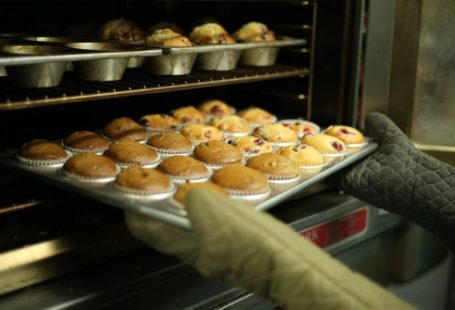 Baking Oven - person holds tray of muffins on tray